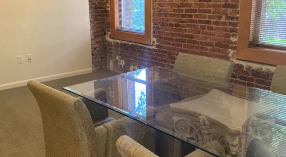 Live work space approximately 1500 sq ft, with hardwood floors, high ceilings and exposed brick wall